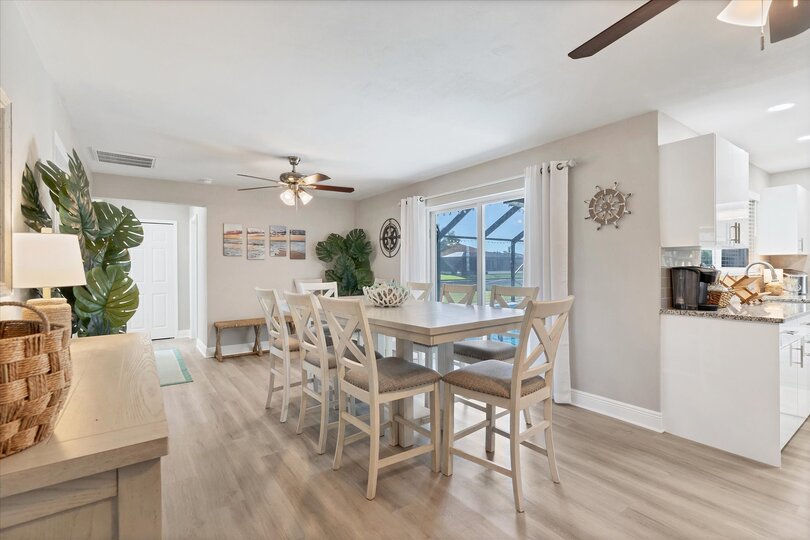 Dining room with additional refrigerator and lanai aceess. Dining table seats 8