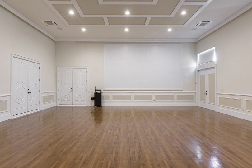 The area is complete with a projection screen and podium with microphone.
