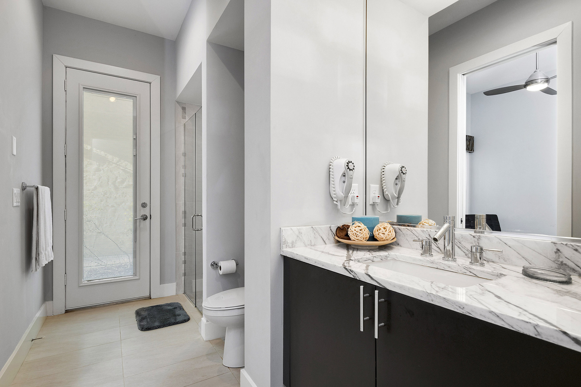 The en-suite bathroom features a glass door walk-in shower, marble vanity, and access door from the hallway