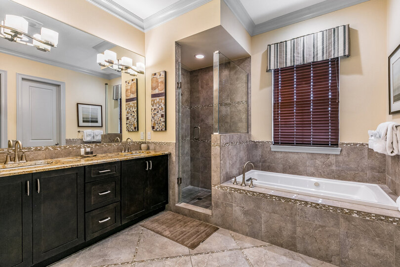 The en-suite bathroom has glass door walk-in shower, tub, and dual vanity