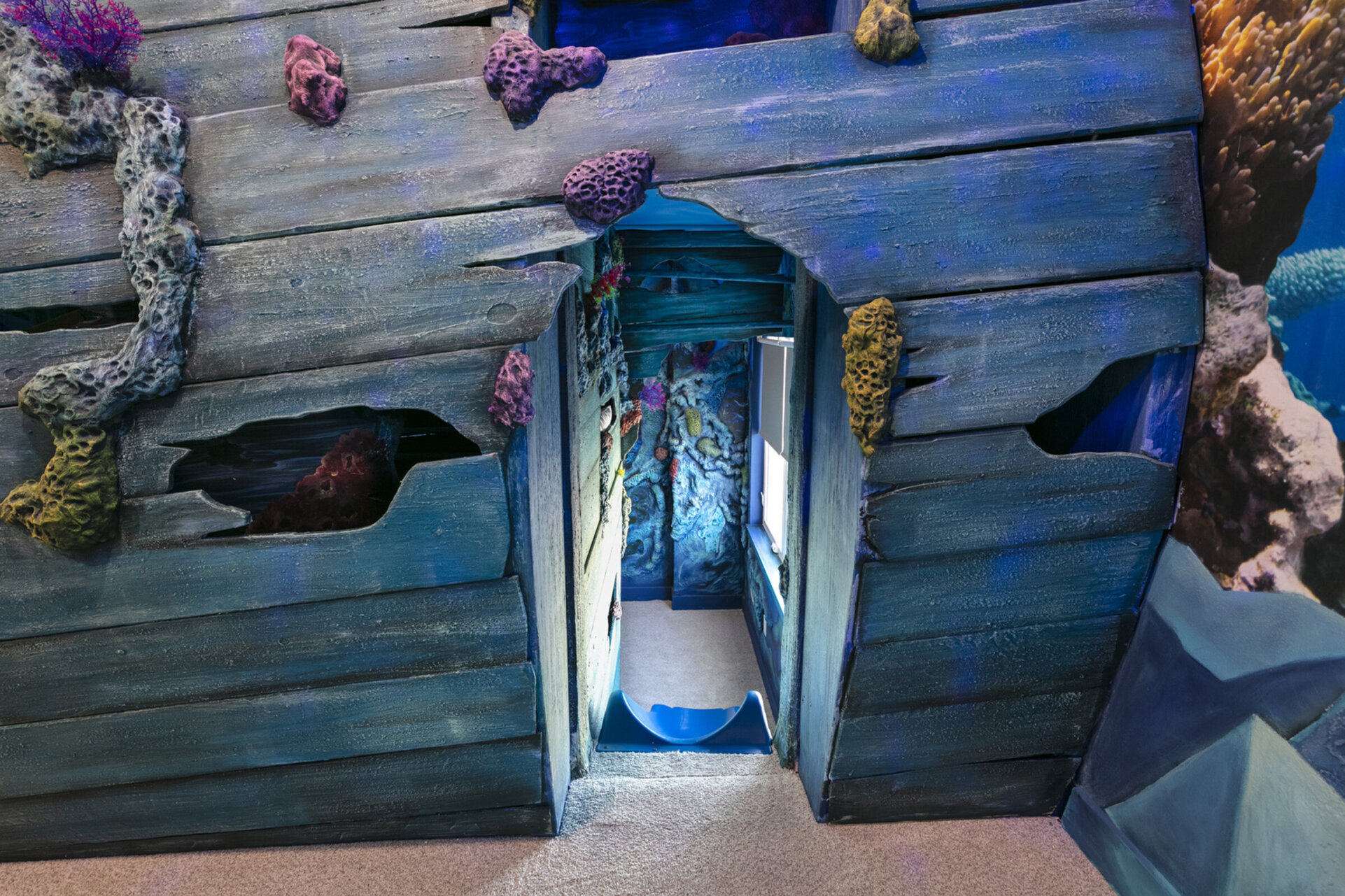 Custom-build bunkbeds even have a slide; the kids wont be able to stop talking about this bedroom!