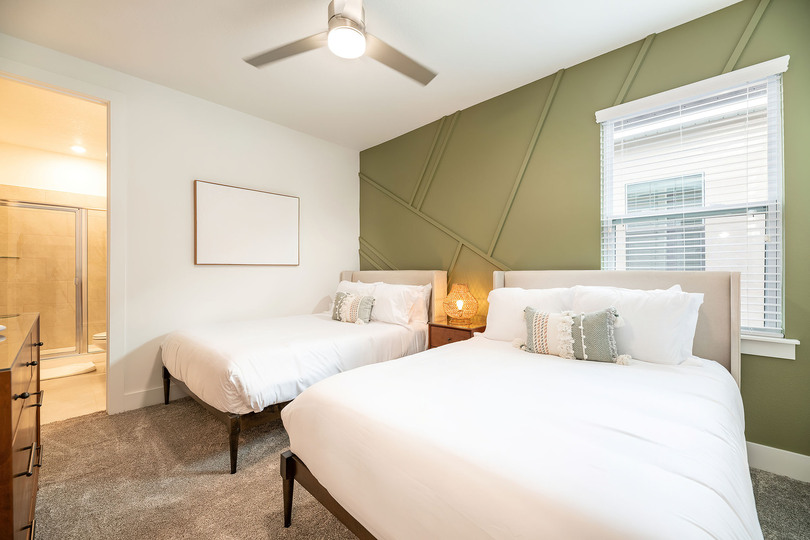 This spacious bedroom features 2x double beds and an en suite bathroom