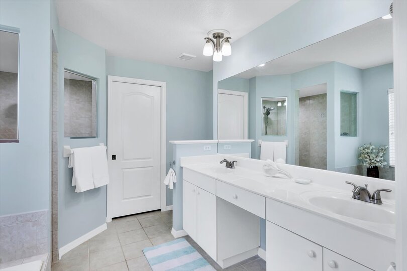 Primary ensuite with walk-in shower, soaking tub, and double vanities