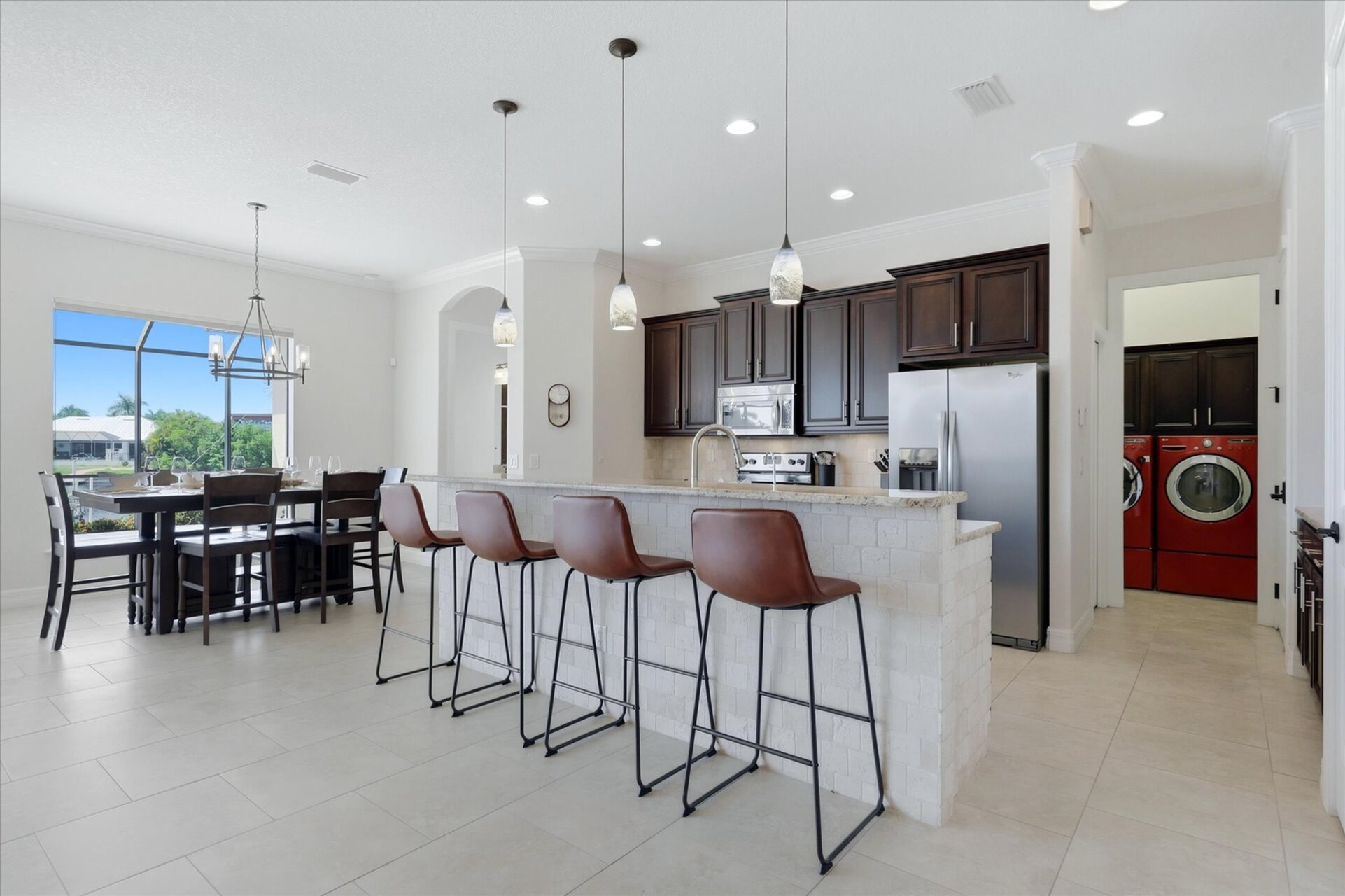 Fully-equipped kitchen overlooking the living room and dining areas. The kitchen features lots of countertop & storage space, and stainless-steel appliances. Kitchen island seats 4