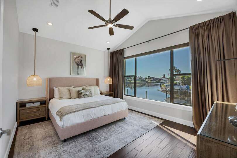 Guest bedroom 1 with king bed 65-inch Smart TV, and fabulous water view